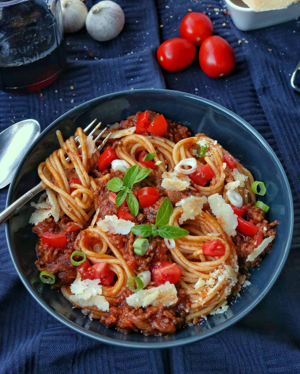 Einen Teller mit Spaghetti Bolognese und Deko