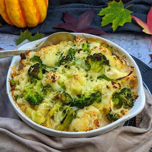 Eine runde Auflaufform mit einem vegetarischen Auflauf. Dahinter Deko.