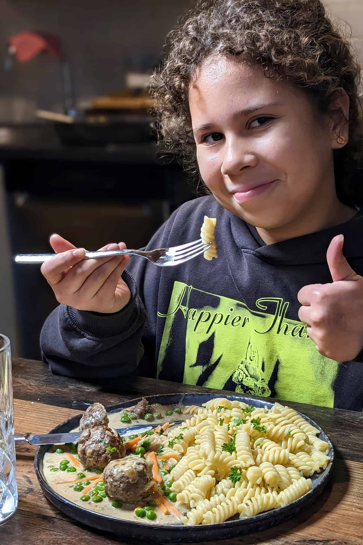 Ein Kind isst eine Portion Wikingertopf mit Nudeln.