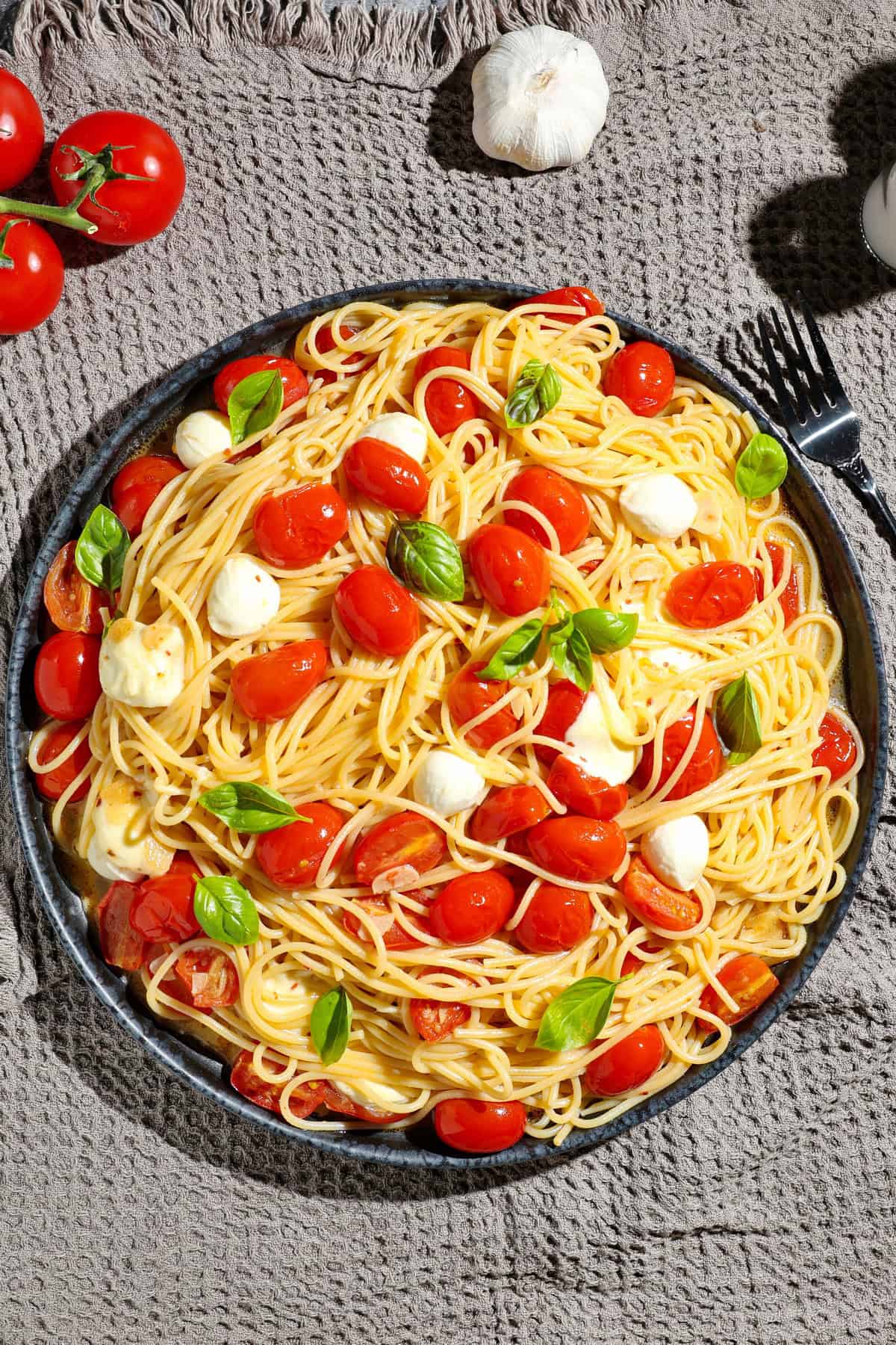 Ein dunkler Servierteller mit Caprese Pasta.