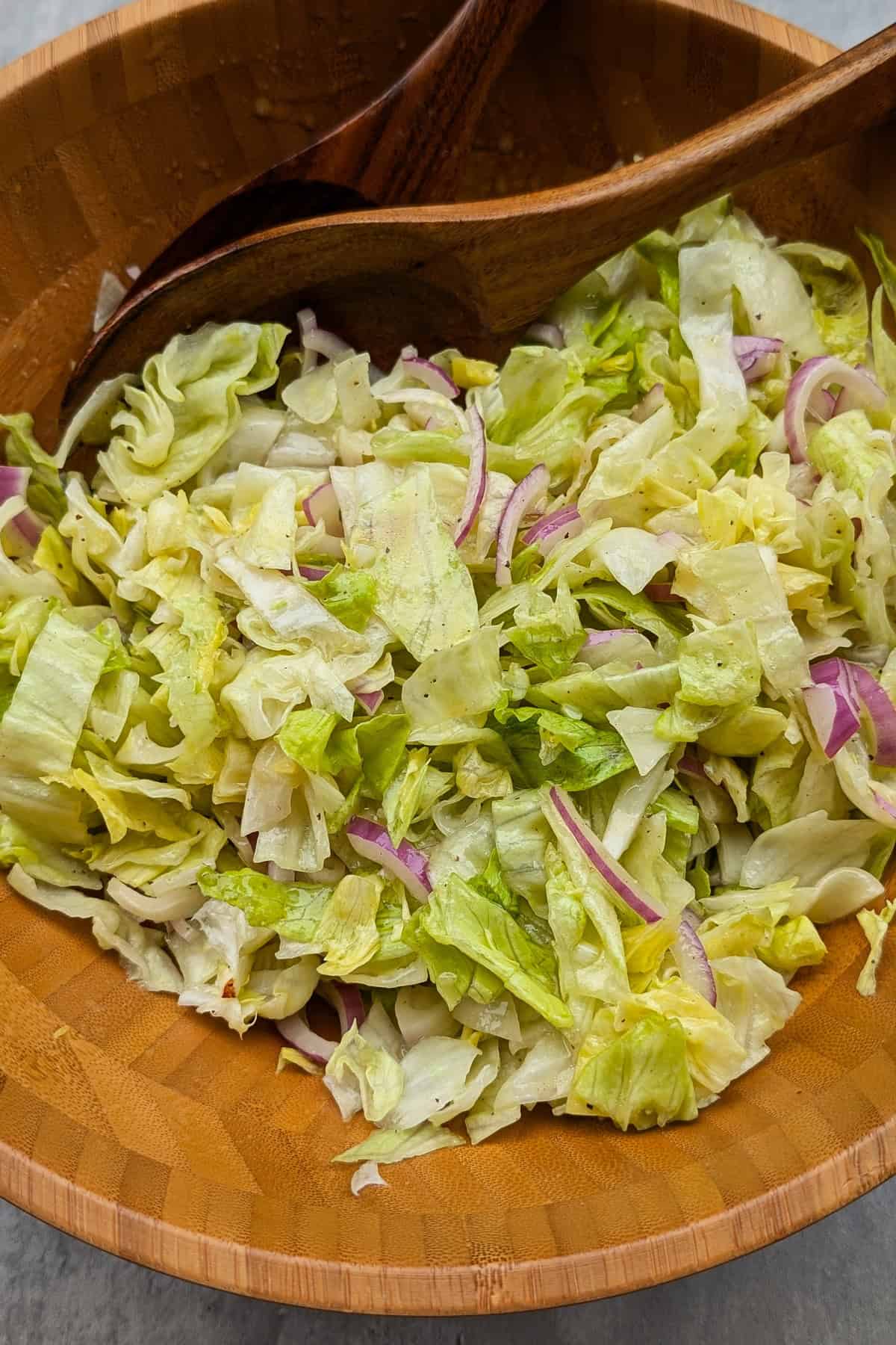 Eine Nahaufnahme einer Salatschüssel mit grünem Salat mit Honig-Senf Dressing.