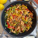 Eine Pfanne mit Hähnchen Fajitas.